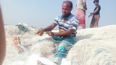 জেলে তার জাল ঠিক করছেন